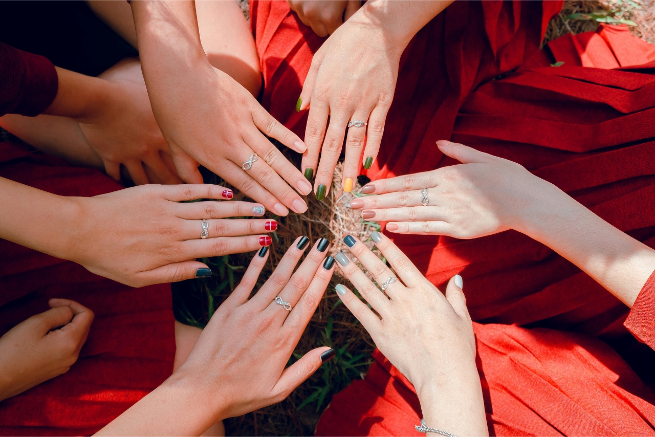 Plusieurs mains ornées de bagues en argent, avec des vernis de différentes couleurs symbolisant diverses émotions